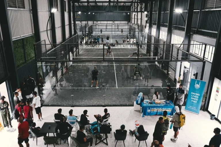 Players gathered courtside during an event at Arturf Padel Arena