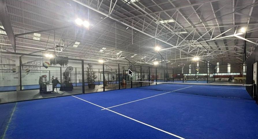 Indoor blue padel courts under a steel roof at Club Padel Stellenbosch