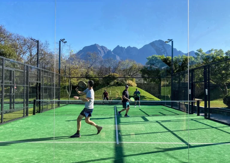 Padel players in action on court at Virgin Active Padel Club Lourensford, with the Helderberg mountains behind