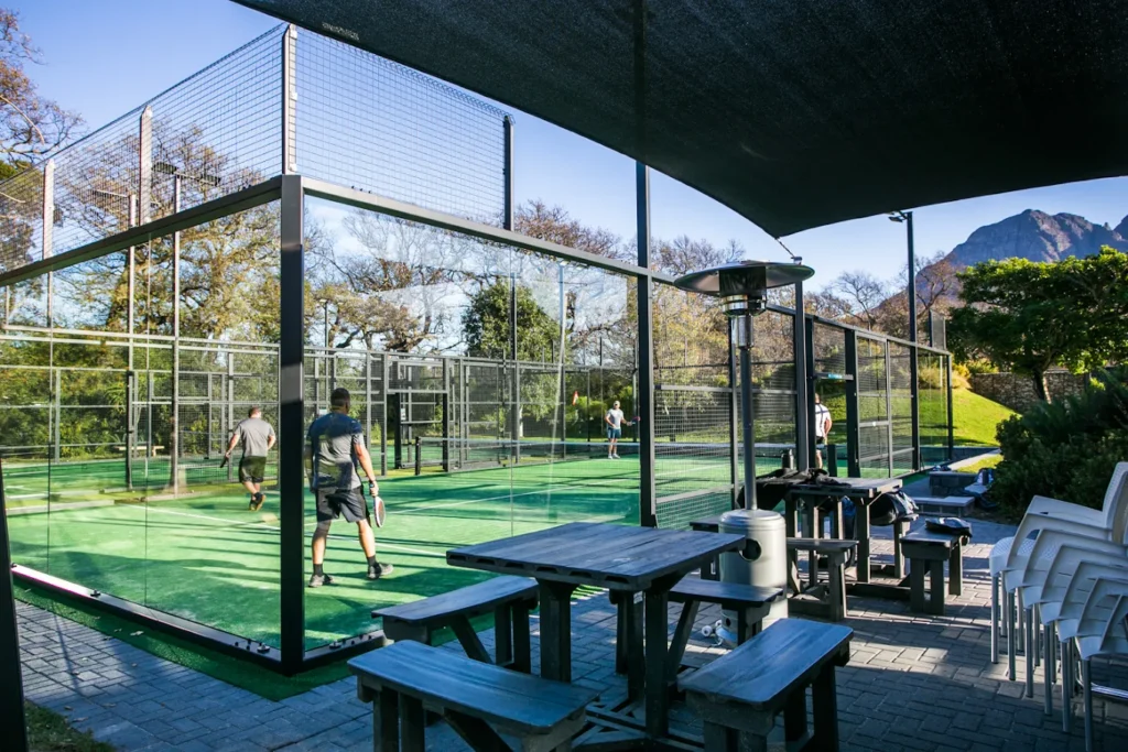 Glass-walled padel courts and shaded seating at Virgin Active Padel Club Lourensford