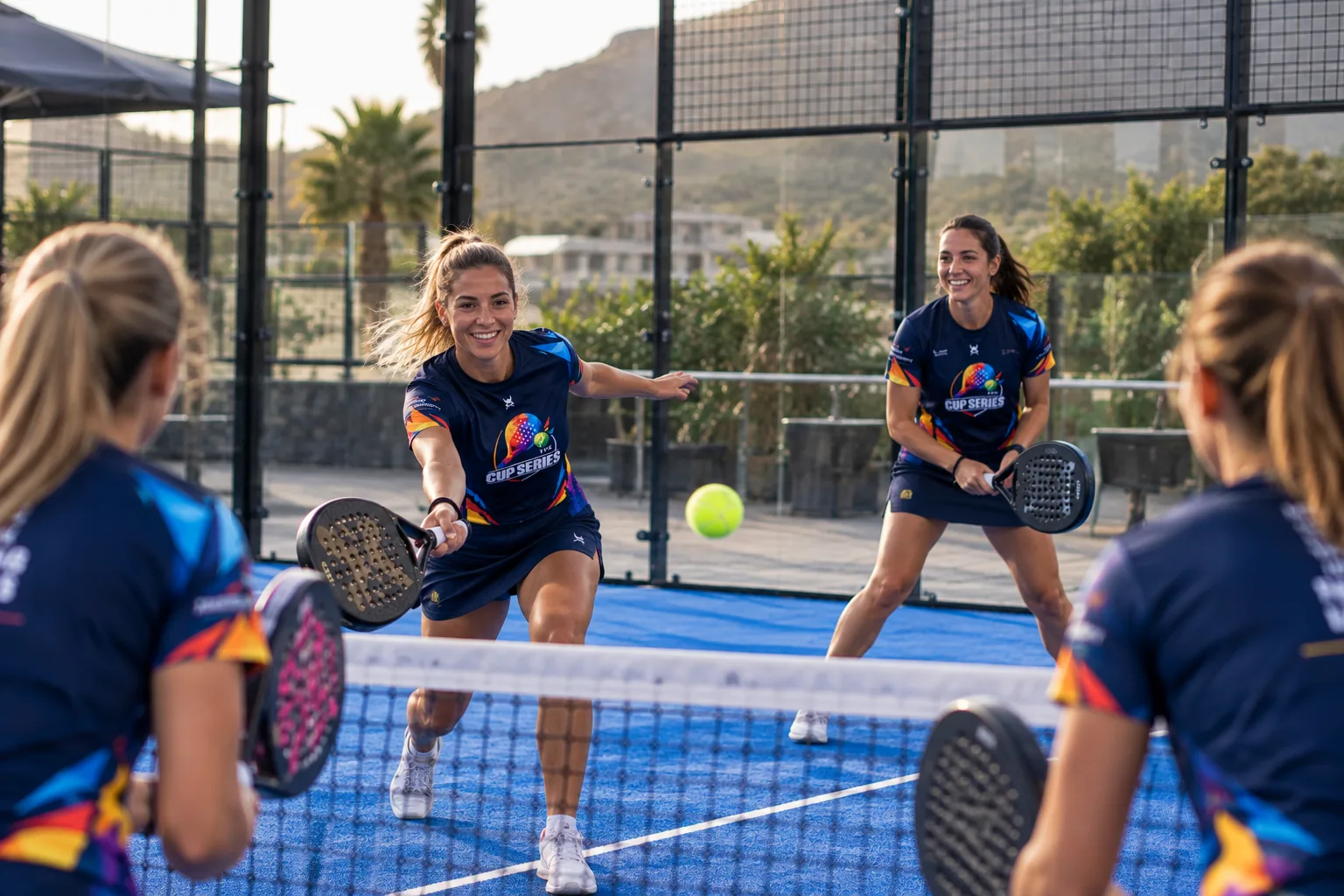 Women's padel doubles in Cup Series shirts, playing at the net